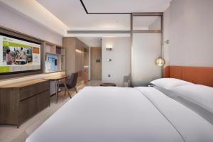 a hotel room with a large bed and a desk at Home2 Suite by Hilton Hengshui Taocheng in Hengshui