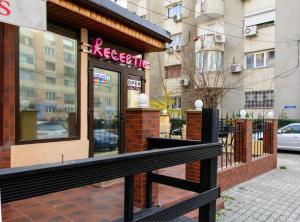 a restaurant with a black fence in front of a building at Eden Boutique in Bucharest