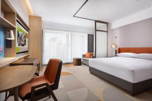 a bedroom with a bed and a desk and a table at Home2 Suite by Hilton Hengshui Taocheng in Hengshui