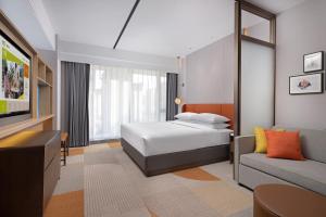 a bedroom with a bed and a couch at Home2 Suite by Hilton Hengshui Taocheng in Hengshui