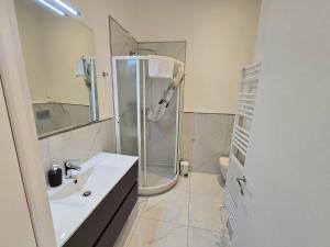 biała łazienka z prysznicem i umywalką w obiekcie LA CALETTA BEACH APARTMENT w mieście La Spezia