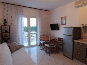a living room with a kitchen and a table with a refrigerator at Apartments Slijepcevic in Hvar