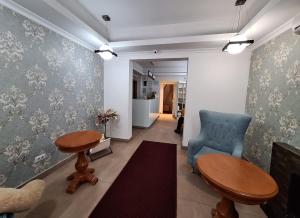 a living room with a blue chair and a table at Eden Boutique in Bucharest