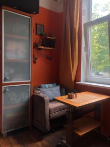 a living room with a table and a couch and a window at Authentic apt in a rustic house, best for a person or couple in Rīga
