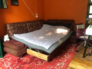 a bed sitting on a couch in a living room at Authentic apt in a rustic house, best for a person or couple in Rīga