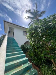 a stairway leading up to a white building with a palm tree at Siri Beach Lodge in Nungwi