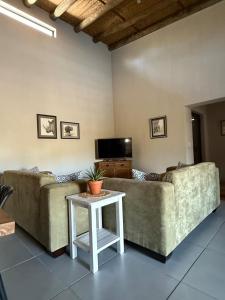 a living room with two couches and a table at Ingonyama Rest in Marloth Park