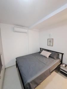 a bedroom with a large bed in a white room at Kustudic Apartments in Tivat