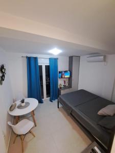 a bedroom with a bed and a table and blue curtains at Kustudic Apartments in Tivat +19 photos