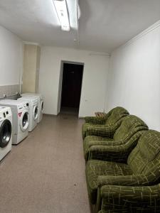 een woonkamer met een bank, een wasmachine en een droger bij Шамшырак in Zhezdi