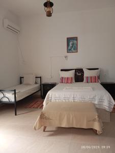 a white bedroom with a bed and a couch at Dar manena in Kairouan