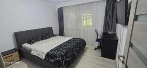 a small bedroom with a bed and a window at ILONA APARTAMENT 3 camere in Râmnicu Vâlcea