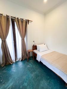 a bedroom with a bed and a table and a window at Siri Beach Lodge in Nungwi