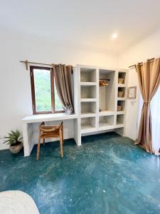 a room with a blue floor and a chair and a window at Siri Beach Lodge in Nungwi