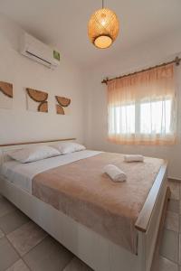 a bedroom with a large bed and a window at Villa Elia by RentalsPro - Olynthos Halkidiki in Olynthos