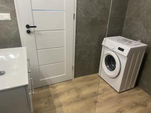 a washing machine in a bathroom next to a sink at Apartmán Bobrov in Bobrów