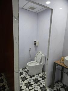 une salle de bain avec WC avec un sol noir et blanc dans l'établissement Homestay Nguyễn hưng, à Hue