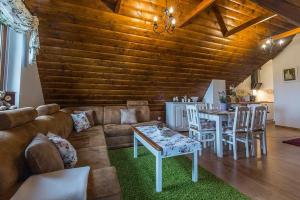 a living room with a couch and a table and chairs at Apartament Murzasichle Gościna na Wierchu in Murzasichle +43 photos