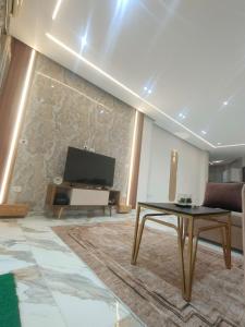 a living room with a tv and a couch and a table at la vi -panorama sea in Hurghada