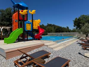 a pool with a playground with chairs and a slide at Moana in Banjole