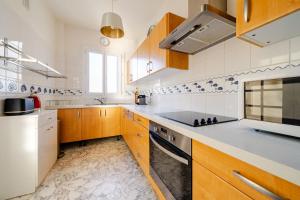 a kitchen with wooden cabinets and a stove top oven at Juan les pins, premium, sea view, sleeps 6 in Juan-les-Pins +18 photos