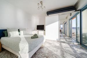 a white bedroom with a large bed and sliding glass doors at Juan les pins, premium, sea view, sleeps 6 in Juan-les-Pins