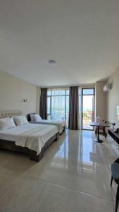 a large bedroom with two beds and a large window at Nike aghmashenebeli str 158 in Kobuleti