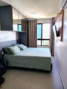 a bedroom with a large bed and a television at La Dolce Vita in Maceió