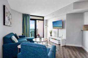 a living room with a blue couch and a table at Fabulous Angled Oceanfront Suite! CR1701 in Myrtle Beach