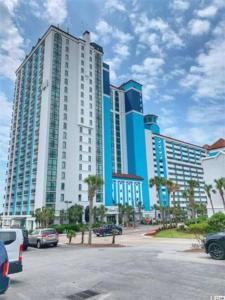 a large building with cars parked in a parking lot at Fabulous Angled Oceanfront Suite! CR1701 in Myrtle Beach