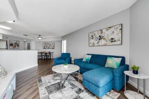 a living room with a blue couch and a table at Fabulous Angled Oceanfront Suite! CR1701 in Myrtle Beach