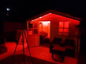 a small house with red lights in the dark at Unterkunft FERIENHAUS "HUMMELCASA" IM HUMMELGAU UNWEIT BAYREUTH FÜR MAX 5 PERSONEN in Creez +14 photos