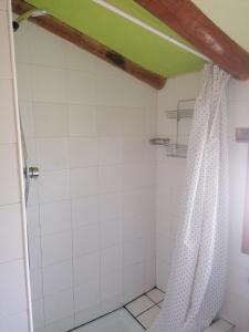 Un baño con ducha con azulejos blancos. en Casa Gil, en Loporzano