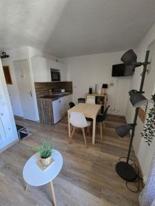 a living room with a table and a kitchen at Appartement chaleureux in Risoul