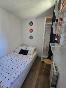 a small bedroom with a bed and a chair at Appartement chaleureux in Risoul