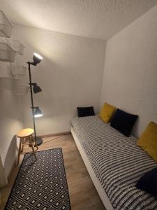 a small room with two beds and a lamp at Appartement chaleureux in Risoul