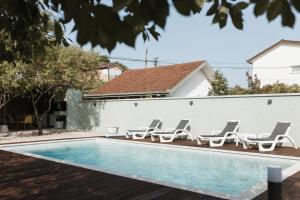 a pool with lounge chairs and a house at Almond Buna PoolHouse in Mostar