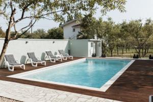 a swimming pool with lounge chairs and a house at Almond Buna PoolHouse in Mostar