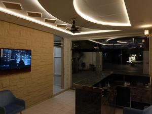 a living room with a tv on a wall at Hotel Haven Suite in Lahore