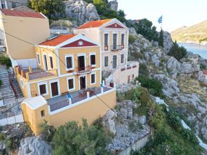 a house on the side of a mountain at Lirenou Scala Vista in Symi