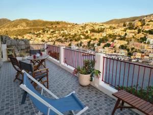 a balcony with chairs and a table and a view at Lirenou Scala Vista in Symi +47 photos