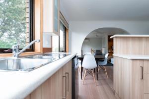 a kitchen with a sink and a dining room at Bright and Beautiful Near the Gorge with Parking in Royal Park +12 photos