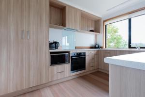 a kitchen with wooden cabinets and a counter top at Bright and Beautiful Near the Gorge with Parking in Royal Park
