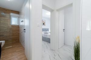 a white bathroom with a bed and a shower at Apartment Cvit in Trogir +29 photos