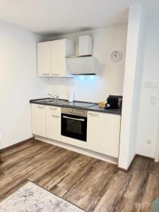 a kitchen with white cabinets and a stove at Apartment in Zentrumsnähe NETFLIX SELF CHECK-IN in Augsburg