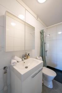 a white bathroom with a sink and a toilet at Steam Apartments - Eidhøgda 6 in Tromsø