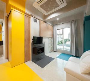 un salon avec un canapé et une télévision dans l'établissement BOB Hostel सुख सदन ひだまり庵 파란달여관, à Bangkok