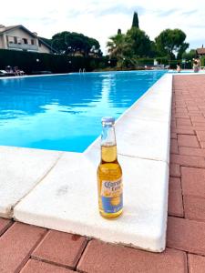 eine Flasche Bier neben einem Pool in der Unterkunft Sosien Apartments in Desenzano del Garda