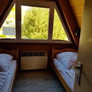 zwei Betten in einem Zimmer mit zwei Fenstern in der Unterkunft Ferienhaus Ostseeküste in Damp