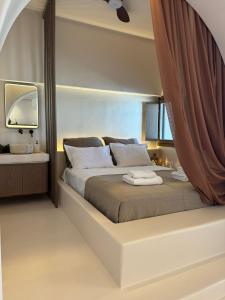 a bedroom with a large bed with a curtain around it at Conte Mykonos II in Aggelika +40 photos